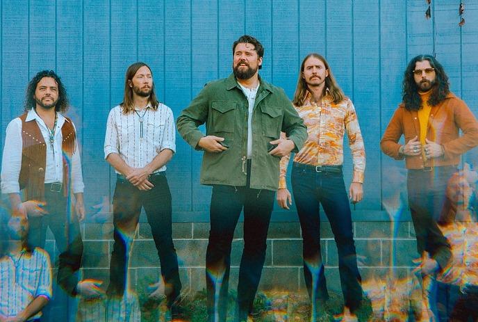 The Sheepdogs: long-haired, bearded men in retro shirts against blue wall with ghostly effect.