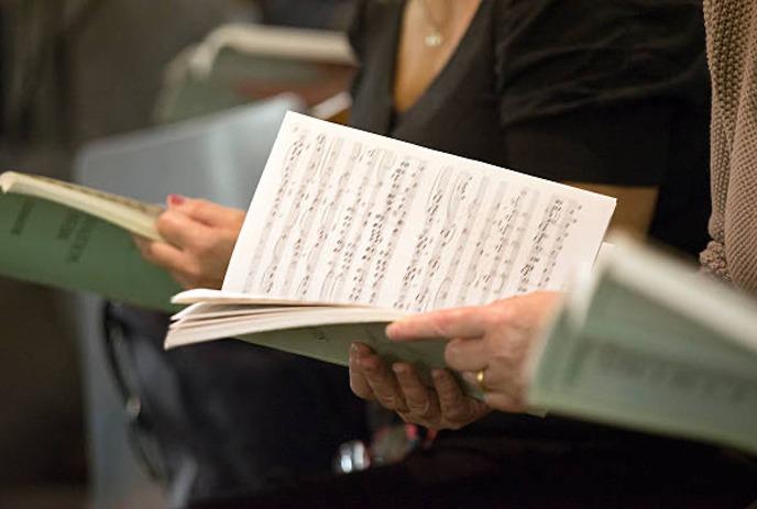 Choir group with books open on a red background with snowflakes