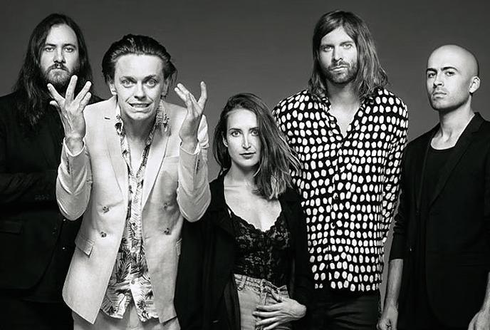 A black and white photo of the 5 members of July Talk, all making different poses while looking at the camera.