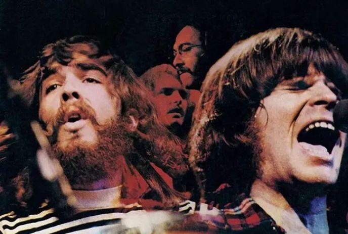 A vibrant photo of a band performing energetically on stage, with singers passionately singing into microphones.