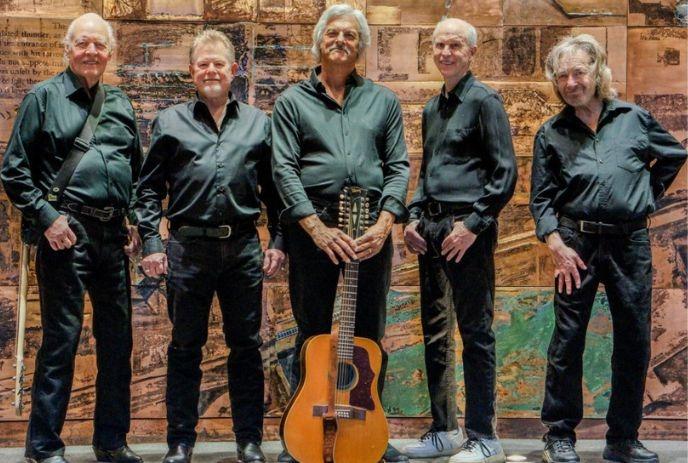 The 5 band members of The Lightfoot Band standing beside one another wearing green shirts and posing for the camera.