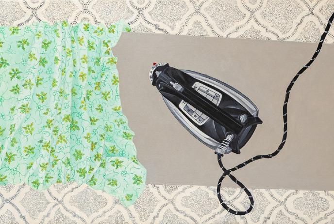 A black iron resting on a green floral fabric against a patterned beige background.