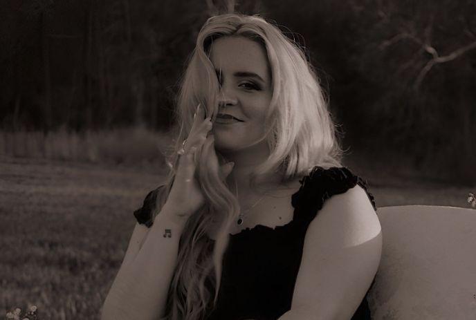 Sarina Haggarty smiling in a black and white portrait posing for a picture.