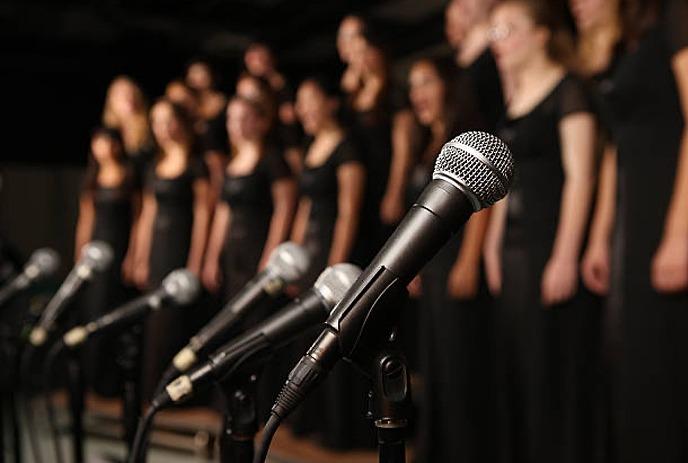 Red image of choir with green bough, red bow and gold bells in one corner.