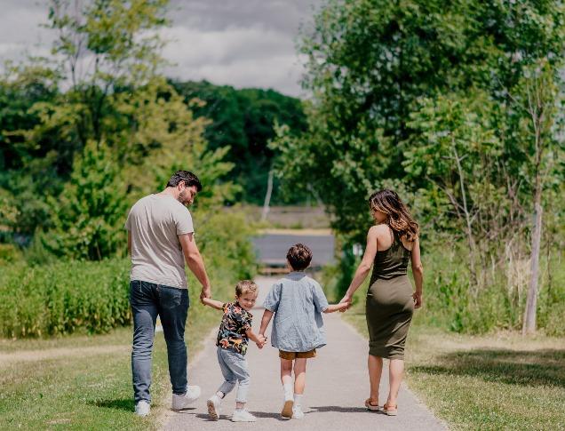 A family of four walking on a park trail in London, Ontario.