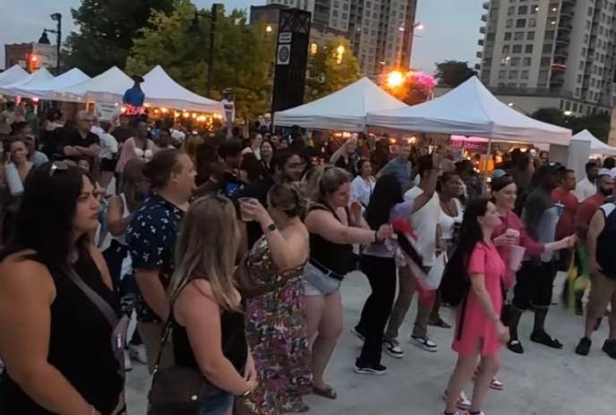 Large gathering of people in the Market Square enjoying the music.