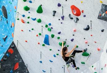 A person climbing a large wall at the Junction Climbing Centre located in London, Ontario.