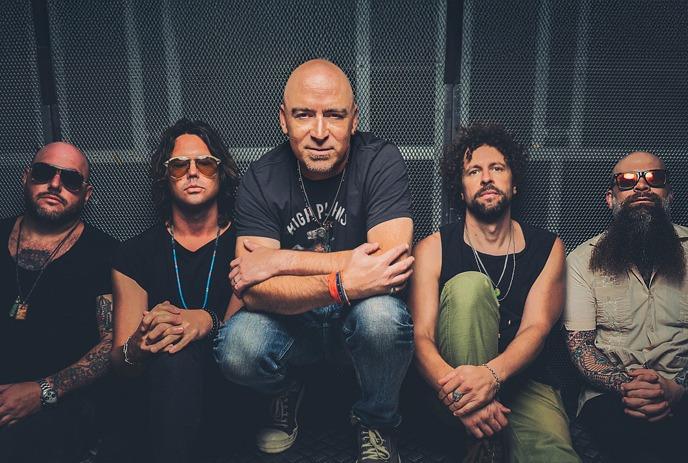 Five band members pose against a moody, cloudy backdrop: dramatic lighting and rock-style outfits.