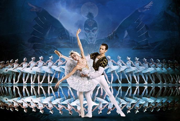 Swan Lake poster with a ballerina, partner, and dancers on a mystical backdrop.