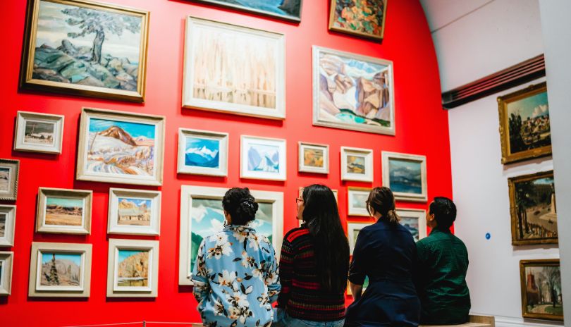 People observing several works of art on display at Museum London located in London, Ontario