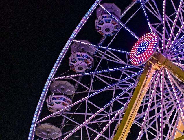 A night shot of the Western Fair with rides and attractions lighting up the night sky.