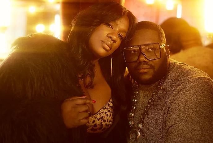 The War and Treaty band members, a woman in fur coat and leopard top leaning on a man with glasses and necklace,