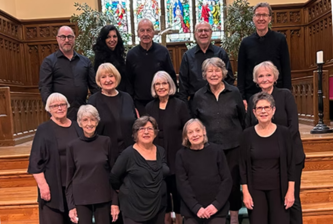 The Laudamus Bells choir group gather together on a church altar for a group photo.